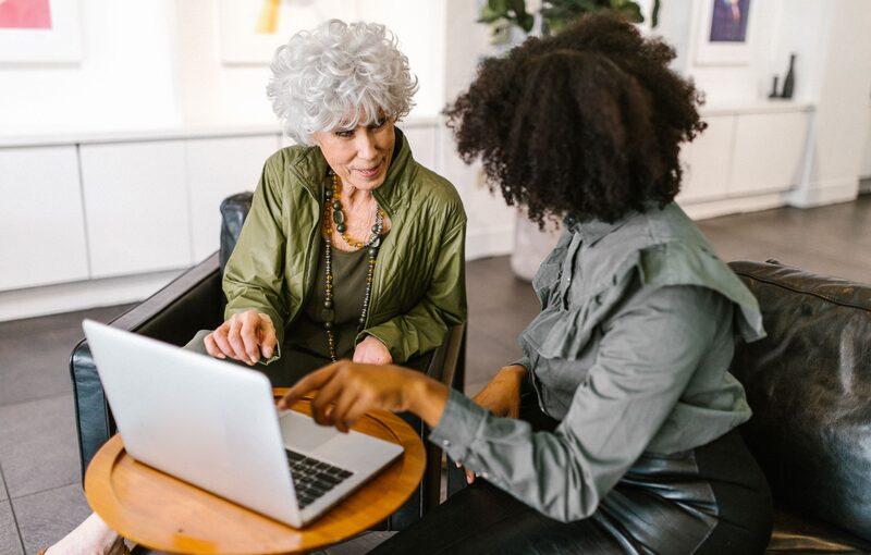 Coach and candidate preparing a CV together on a laptop