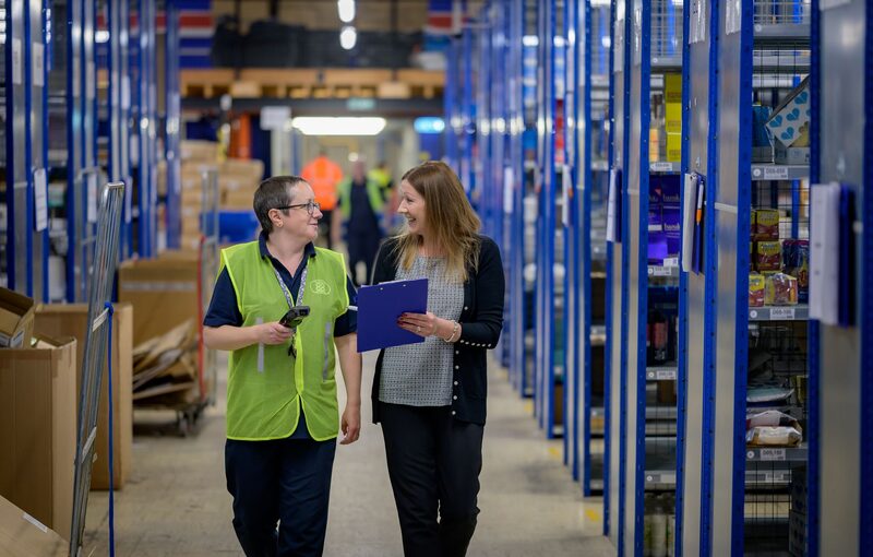 Employer and warehouse worker walking together in a distribution centre