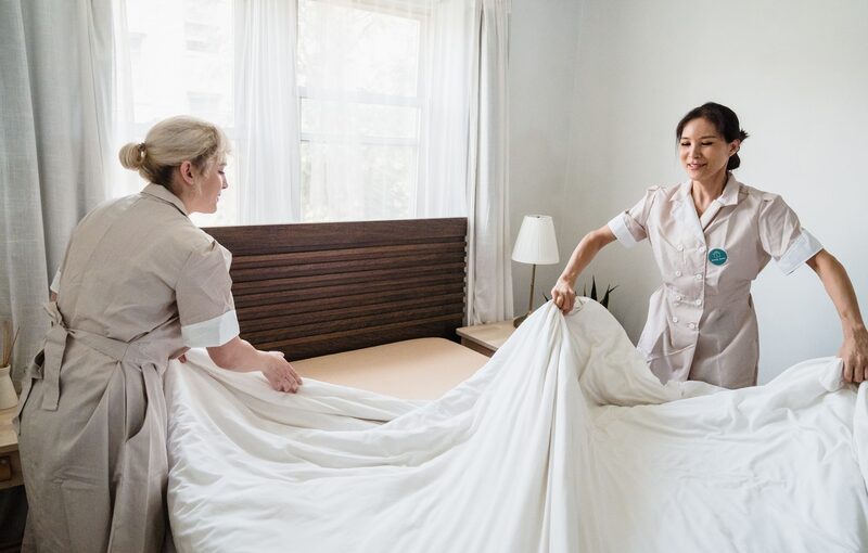 Two housekeepers preparing a hotel room together