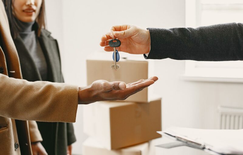Handing over the keys of a new accommodation with moving boxes