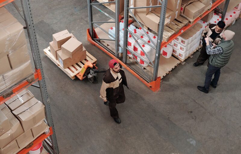 Warehouse workers preparing orders among storage racks