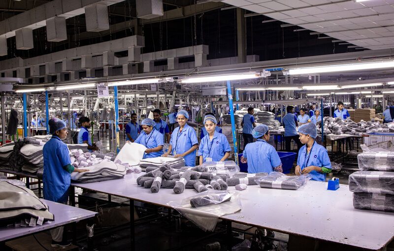 Workers packing products along an industrial production line